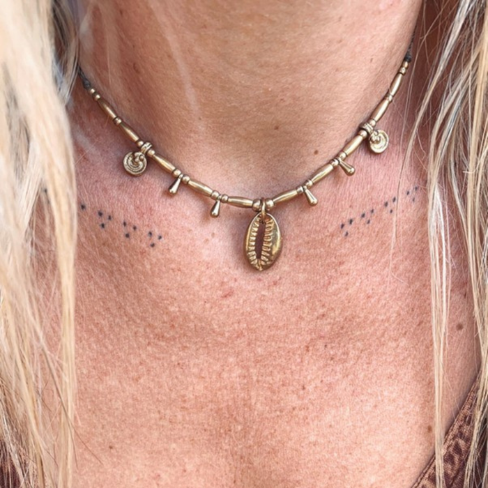 Handmade cowrie brass beaded necklace with natural shells and brass charms on waxed cord
