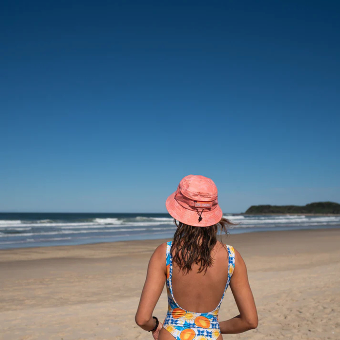 Person wearing Florals + Corals coral surf hat on the water