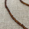 Brown rustic string of beads necklace showing natural variations, earthy coastal style