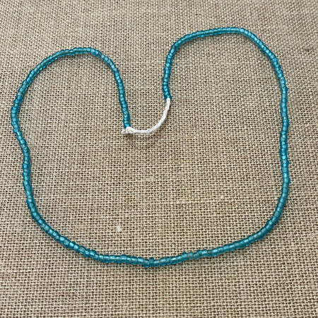 Raw string of beads necklace in blue showing rustic natural texture, coastal accessory