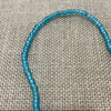 Raw string of beads necklace in blue showing rustic natural texture, coastal accessory