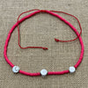 Red shiva shell necklace showing three natural shells on coloured cord, coastal accessory