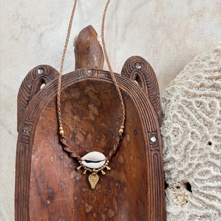 Close-up of cowrie shell macrame choker showing detailed knotwork and natural shell, adjustable coastal necklace design
