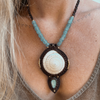 Close-up of handmade larimar macrame necklace showing natural ocean-blue stone and unique beach-found shell detail
