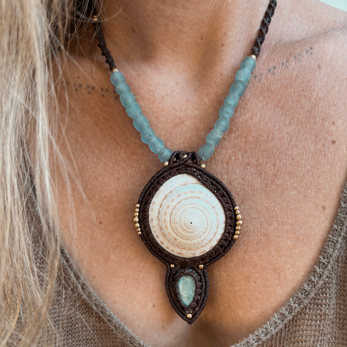 Close-up of handmade larimar macrame necklace showing natural ocean-blue stone and unique beach-found shell detail