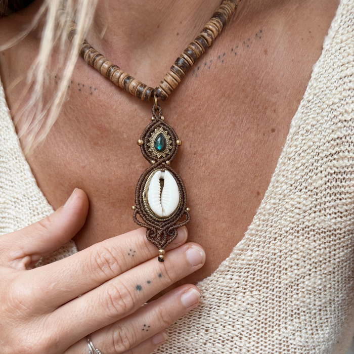 Handmade cowrie and labradorite necklace styled on model, showcasing adjustable macrame design and ocean-inspired aesthetic