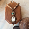 Close-up of cowrie shell and labradorite macrame necklace showing natural materials and artisan knotwork detail