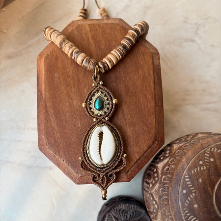 Close-up of cowrie shell and labradorite macrame necklace showing natural materials and artisan knotwork detail