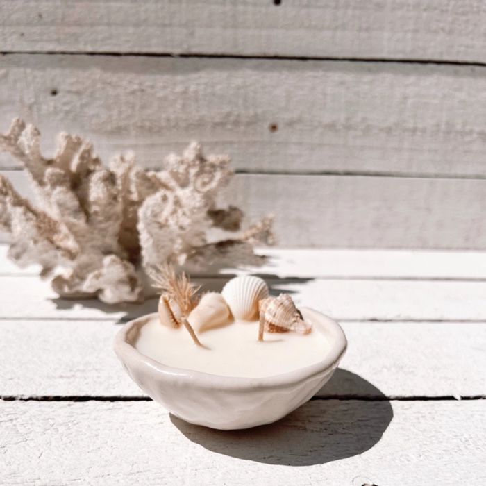 Seashell pinched ceramic candle with natural seashells and dried botanicals