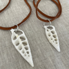 Natural cut shell necklace showing raw unpolished shell detail on leather cord, earthy coastal style