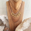 Handmade brass charm necklace with adjustable cord worn as choker