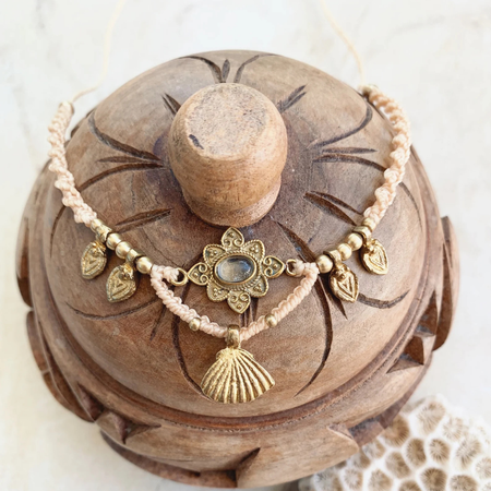 Detail view of quartz crystal and brass charm on bohemian necklace