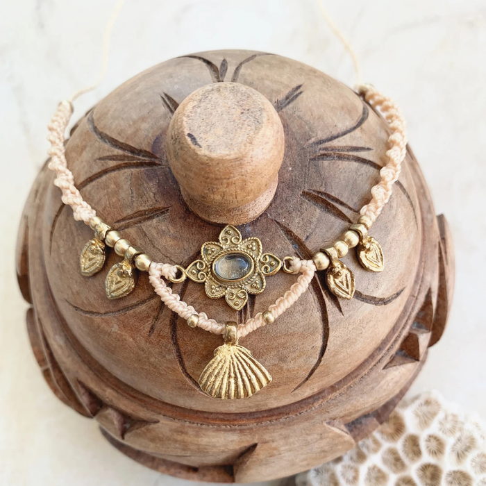 Detail view of quartz crystal and brass charm on bohemian necklace