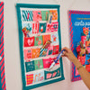 Fabric Advent Calendar with 24 numbered pockets, 39 × 58.5 cm, includes plastic tubing for easy hanging—ideal for daily Christmas treats.