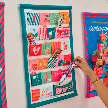 Fabric Advent Calendar with 24 numbered pockets, 39 × 58.5 cm, includes plastic tubing for easy hanging—ideal for daily Christmas treats.